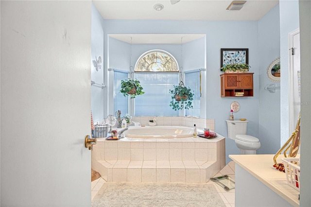 bathroom with tile patterned floors, toilet, and tiled tub