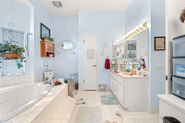 bathroom featuring tiled tub, tile patterned flooring, and vanity