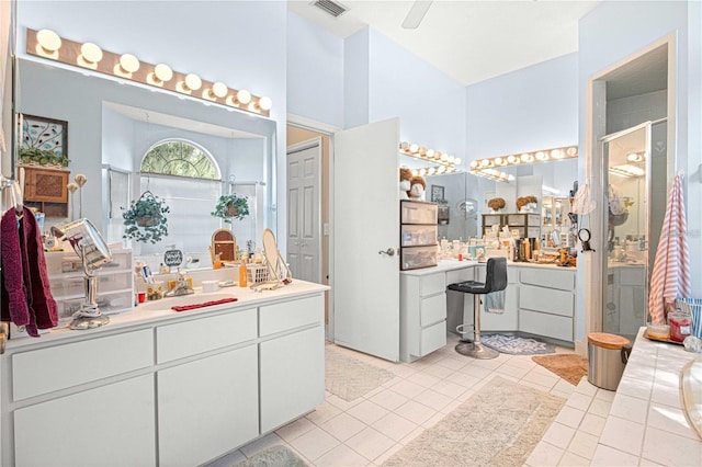 bathroom featuring ceiling fan, tile patterned flooring, vanity, and a shower with shower door