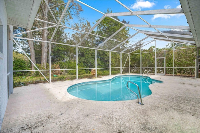 view of pool with glass enclosure and a patio