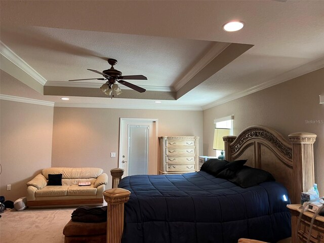 carpeted bedroom featuring a raised ceiling, ceiling fan, and ornamental molding