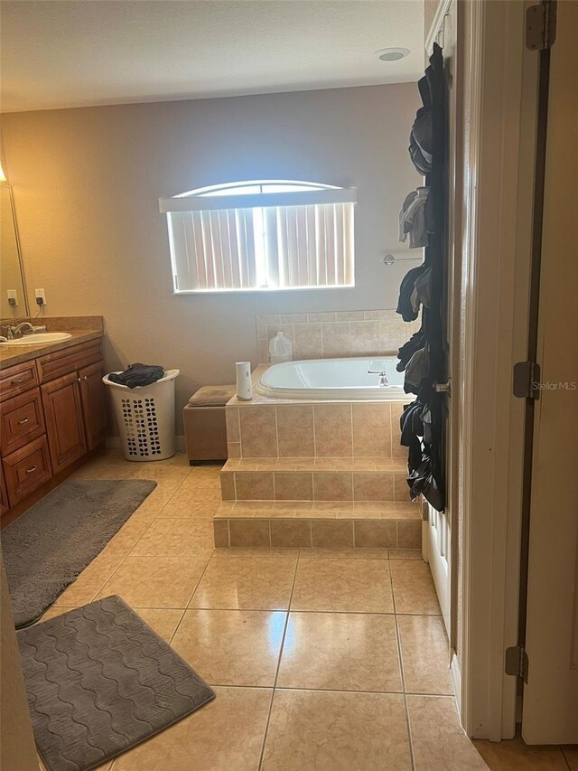 bathroom with vanity, tiled bath, and tile patterned floors