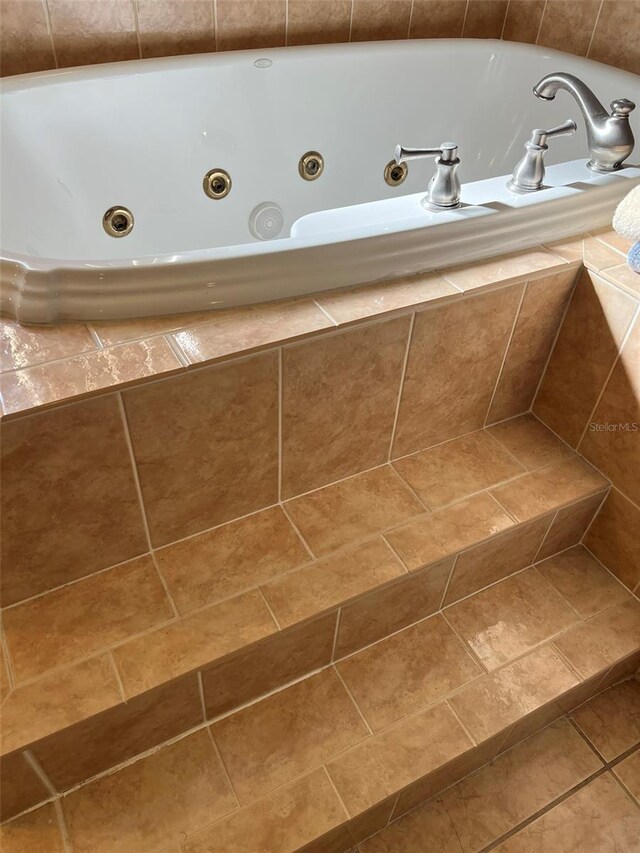 bathroom with a relaxing tiled tub