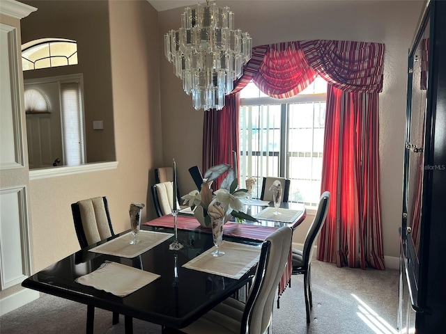 carpeted dining room with a chandelier