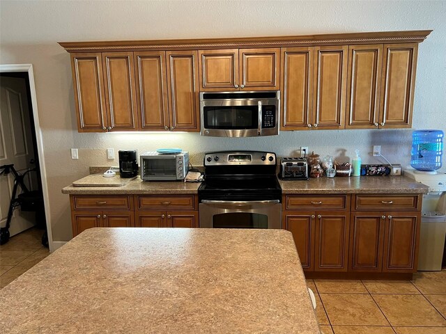 kitchen with light tile patterned floors and appliances with stainless steel finishes