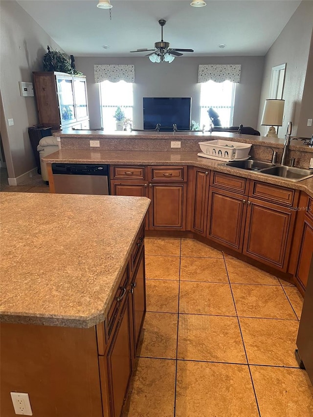 kitchen with light tile patterned flooring, stainless steel dishwasher, a wealth of natural light, and sink