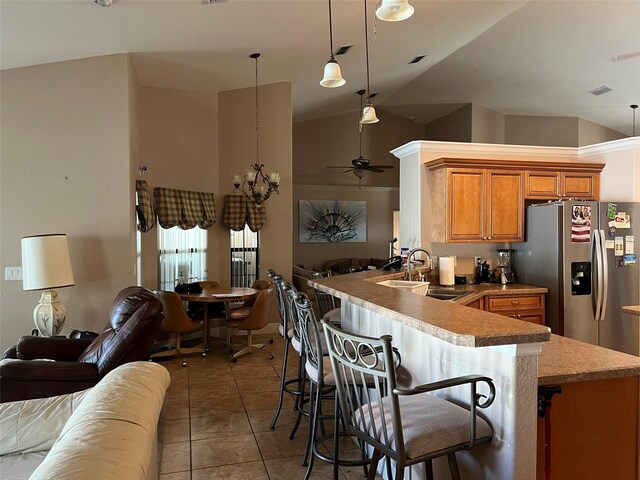 kitchen featuring kitchen peninsula, stainless steel fridge with ice dispenser, vaulted ceiling, and sink