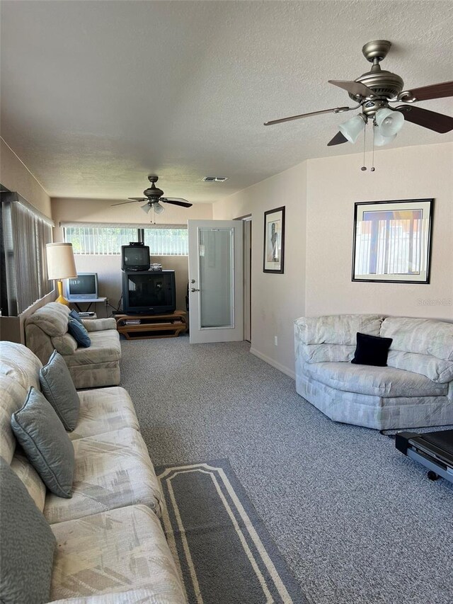 carpeted living room featuring a textured ceiling, plenty of natural light, and ceiling fan