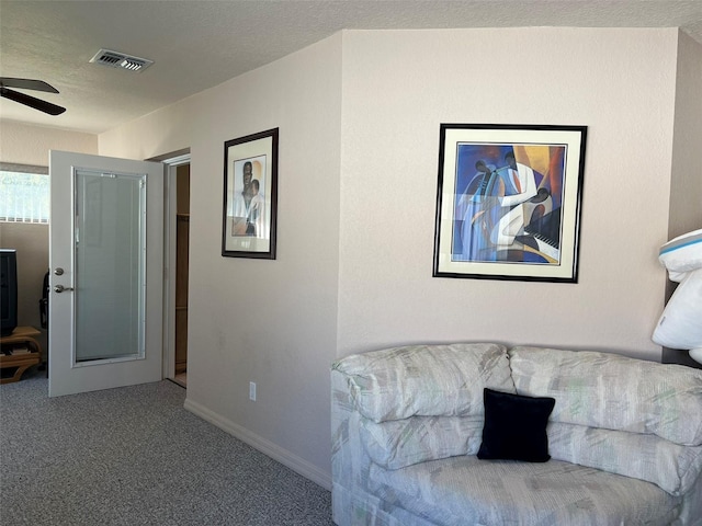 living area with carpet flooring, a textured ceiling, and ceiling fan