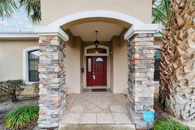 property entrance with stone siding and stucco siding