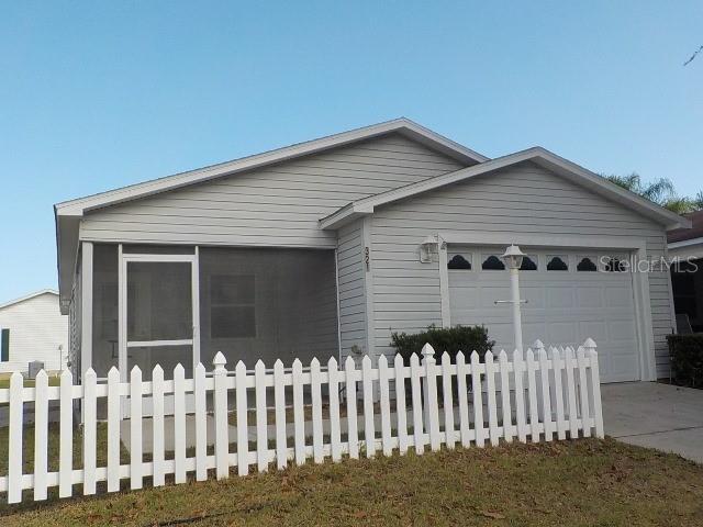 single story home featuring a garage and a sunroom