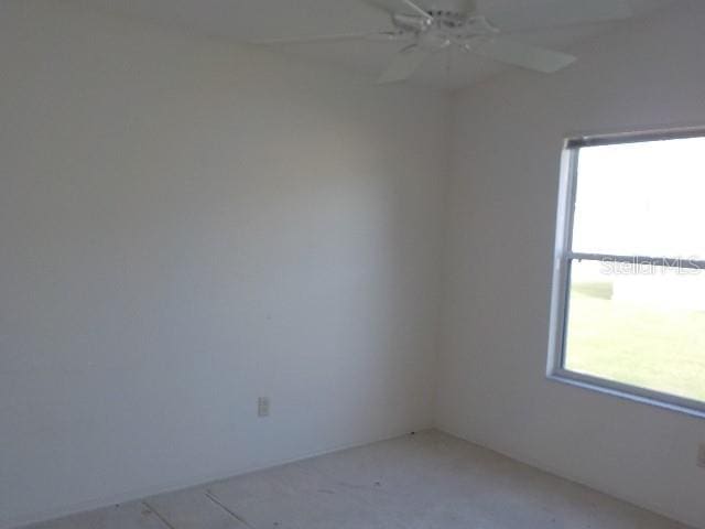 unfurnished room featuring ceiling fan and plenty of natural light