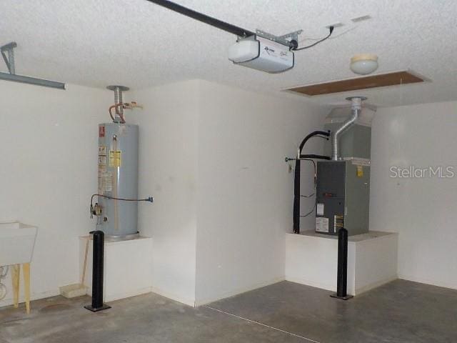 garage with gas water heater, a garage door opener, and heating unit