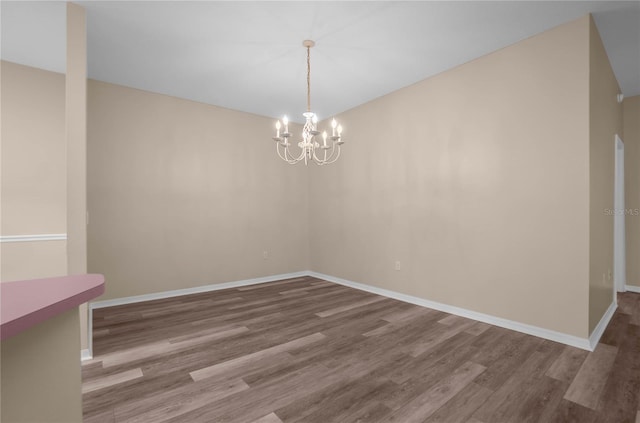 unfurnished dining area featuring a chandelier and hardwood / wood-style flooring