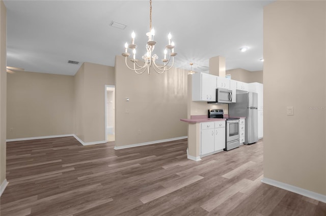 kitchen with pendant lighting, white cabinetry, wood-type flooring, stainless steel appliances, and a chandelier