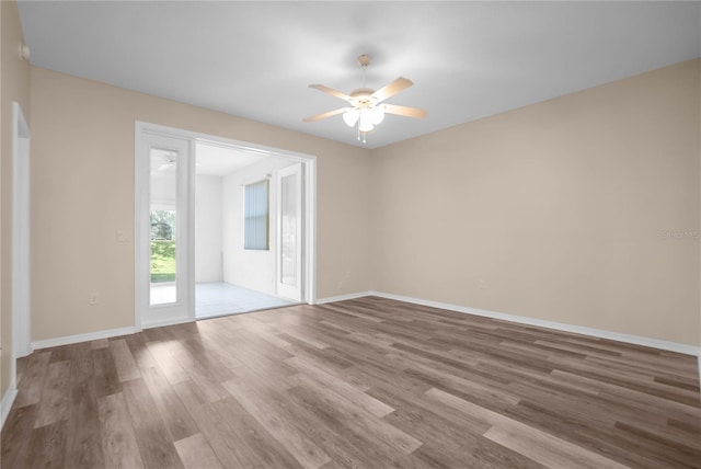 empty room with ceiling fan and hardwood / wood-style flooring