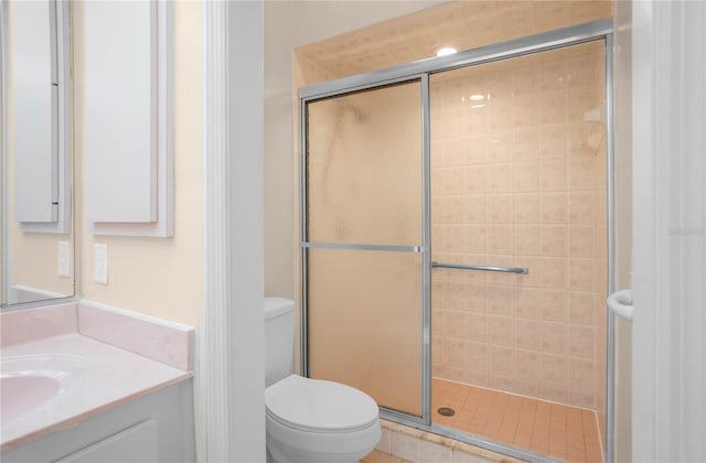 bathroom featuring vanity, toilet, and a shower with shower door