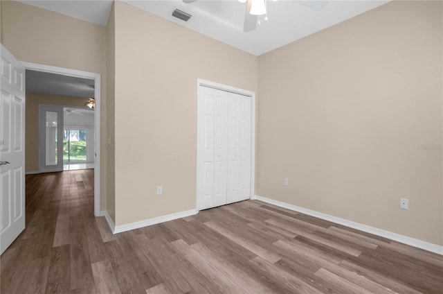 unfurnished bedroom with light wood-type flooring, a closet, and ceiling fan