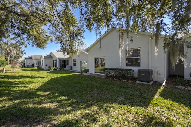 back of property featuring a lawn and central AC unit