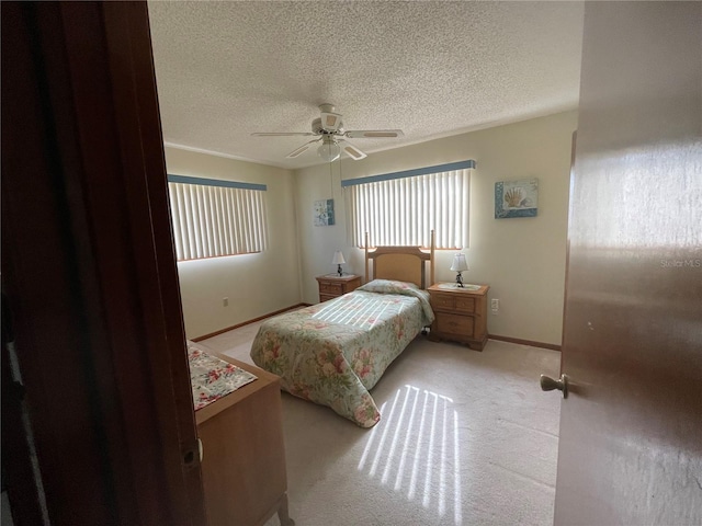 carpeted bedroom featuring a textured ceiling and ceiling fan