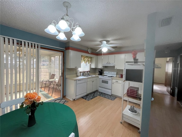 kitchen featuring white cabinetry, sink, hanging light fixtures, white appliances, and ceiling fan with notable chandelier