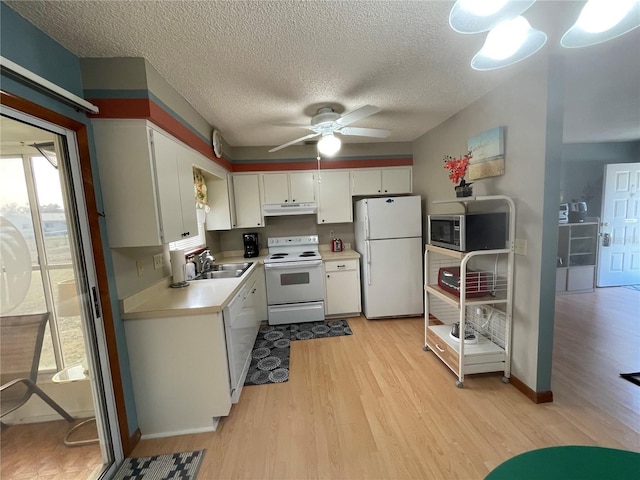 kitchen featuring white appliances, sink, white cabinets, light hardwood / wood-style floors, and plenty of natural light