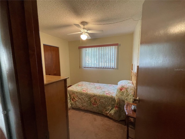 bedroom featuring ceiling fan, carpet, and a textured ceiling