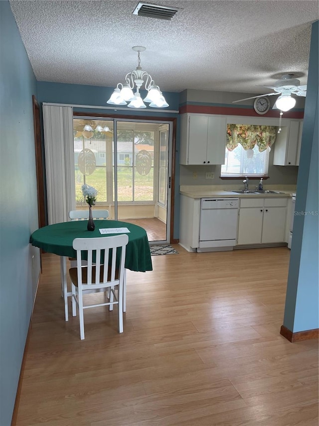 10949 SW 79th Ter, Ocala, FL 34476 - dining space featuring a chandelier, a textured ceiling, light wood-style floors, a ceiling fan, and baseboards