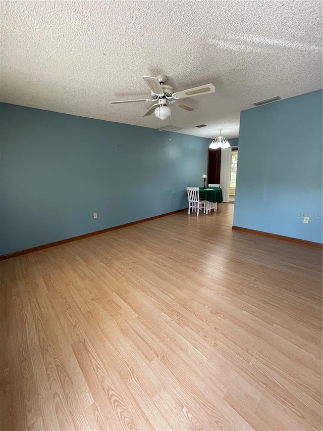 10949 SW 79th Ter, Ocala, FL 34476 - spare room featuring light wood-type flooring, a ceiling fan, a textured ceiling, and baseboards