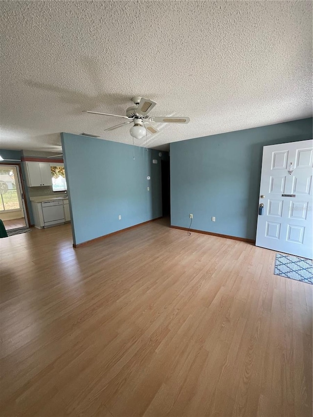 10949 SW 79th Ter, Ocala, FL 34476 - unfurnished living room with a ceiling fan, light wood-type flooring, a textured ceiling, and baseboards