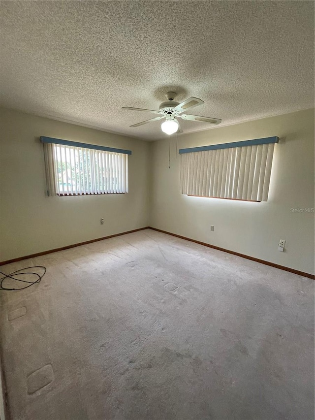 10949 SW 79th Ter, Ocala, FL 34476 - spare room featuring a ceiling fan, a textured ceiling, light carpet, and baseboards