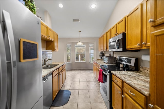 kitchen with light stone counters, sink, light tile patterned floors, and appliances with stainless steel finishes