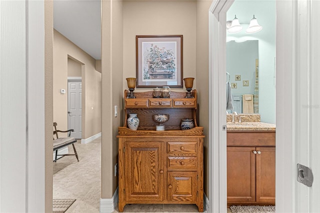 hallway with light tile patterned flooring and sink