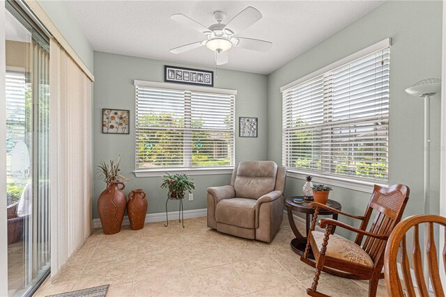 sitting room with ceiling fan, a healthy amount of sunlight, and light tile patterned flooring