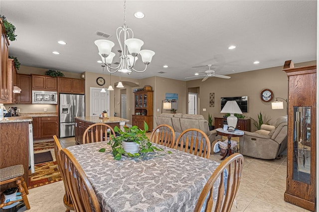 dining room featuring light tile patterned floors and ceiling fan with notable chandelier