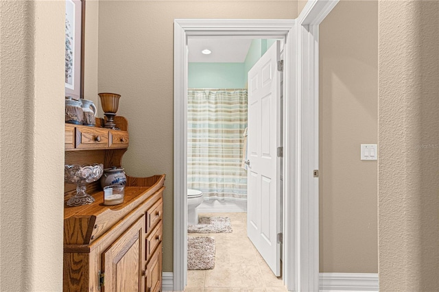 interior space featuring tile patterned floors and toilet