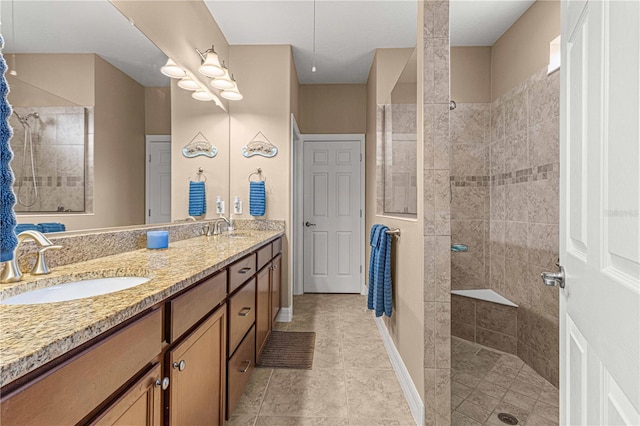 bathroom with tiled shower, vanity, and tile patterned flooring