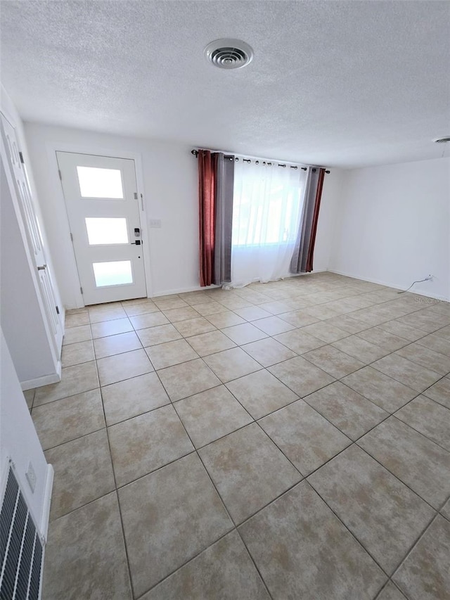 foyer with light tile patterned flooring and a textured ceiling