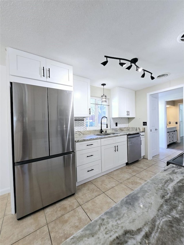 kitchen with white cabinetry, sink, hanging light fixtures, tasteful backsplash, and appliances with stainless steel finishes