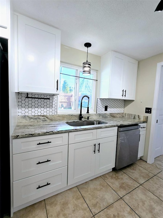 kitchen with tasteful backsplash, sink, dishwasher, white cabinetry, and hanging light fixtures