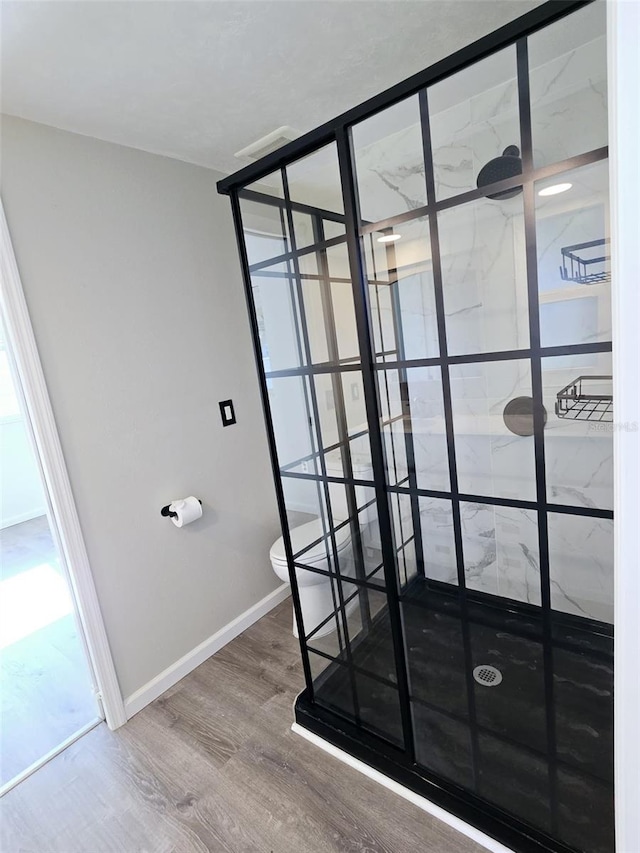 bathroom featuring hardwood / wood-style floors, toilet, and walk in shower