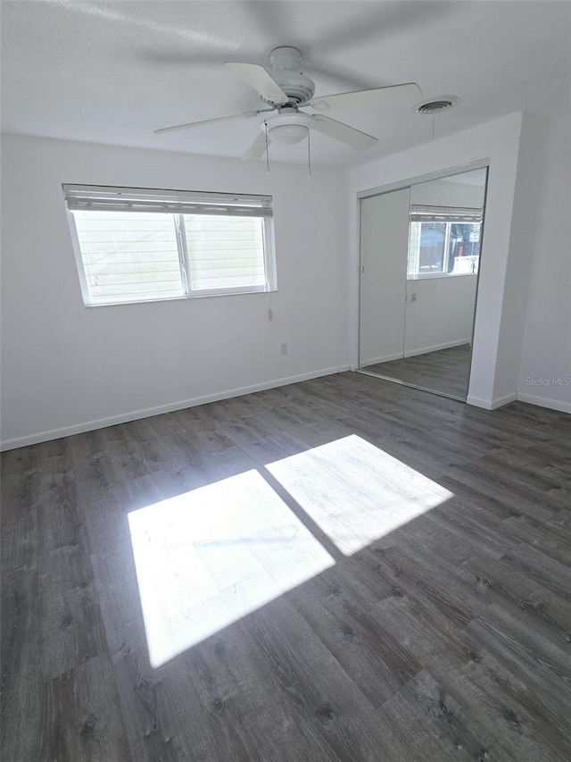 empty room with dark hardwood / wood-style floors and ceiling fan