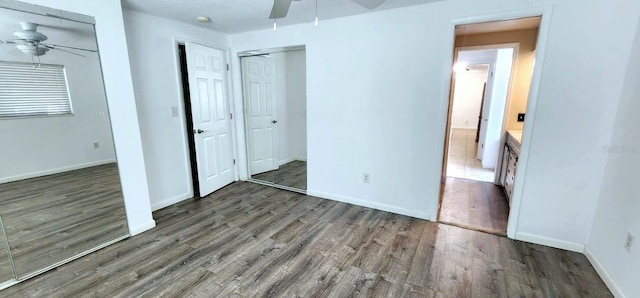 unfurnished bedroom with ceiling fan and dark hardwood / wood-style flooring