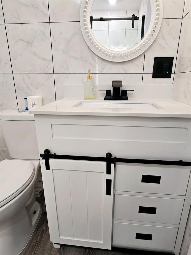 bathroom featuring toilet, vanity, and hardwood / wood-style flooring