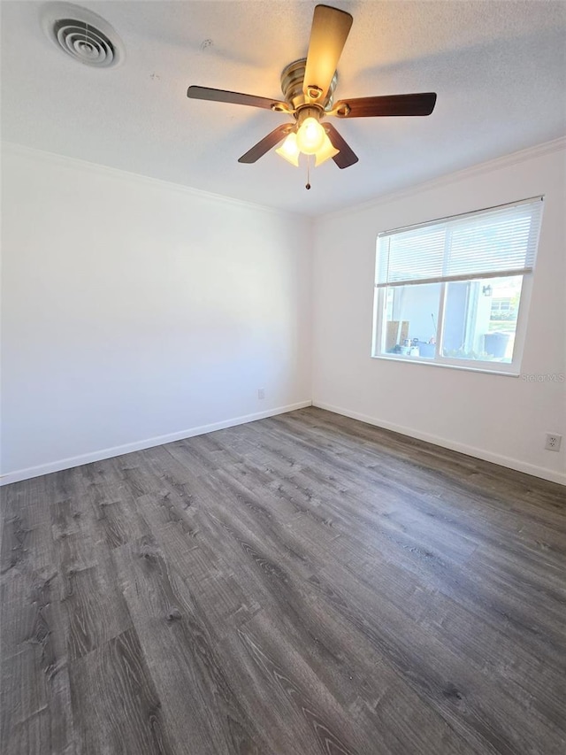 empty room with a textured ceiling, dark wood-type flooring, ceiling fan, and crown molding