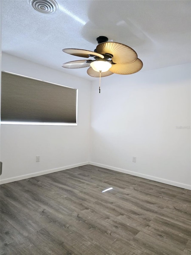 spare room with a textured ceiling, dark hardwood / wood-style flooring, and ceiling fan