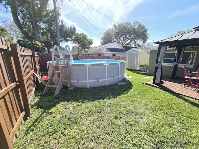 view of yard featuring a fenced in pool, a gazebo, and a storage unit