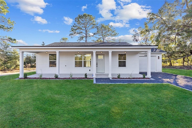 view of front of home featuring covered porch, a garage, and a front lawn