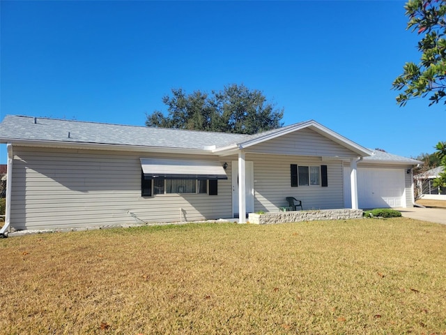 ranch-style house featuring a garage and a front lawn