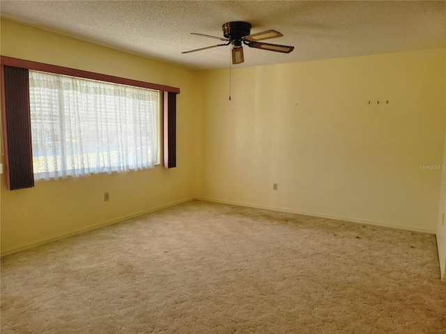 unfurnished room featuring ceiling fan, light carpet, and a textured ceiling